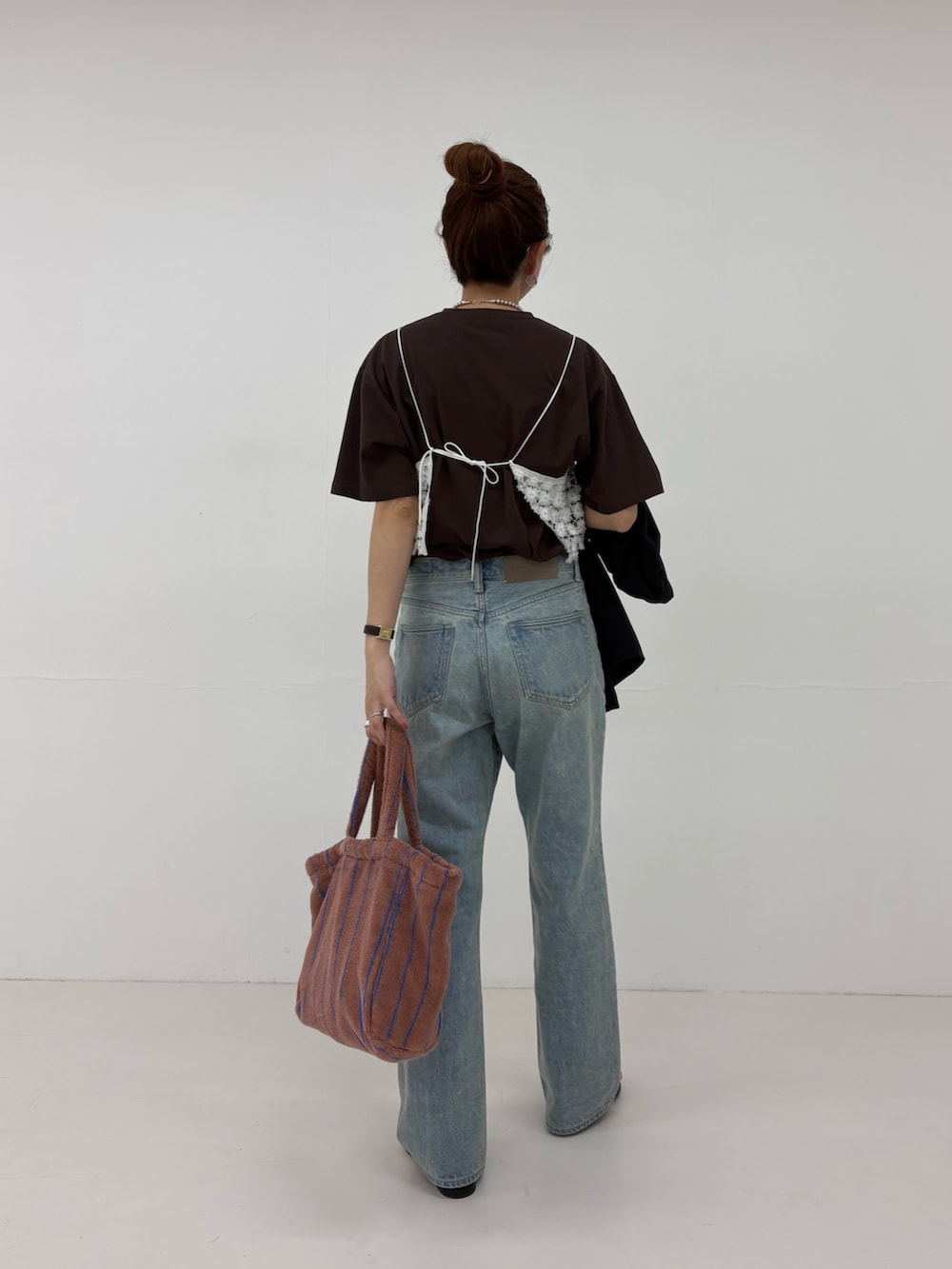 ブルー系のデニムパンツ、ホワイト系のその他トップス、イエロー系のハンドバッグを着用したレディースの春コーディネートの3枚目の写真