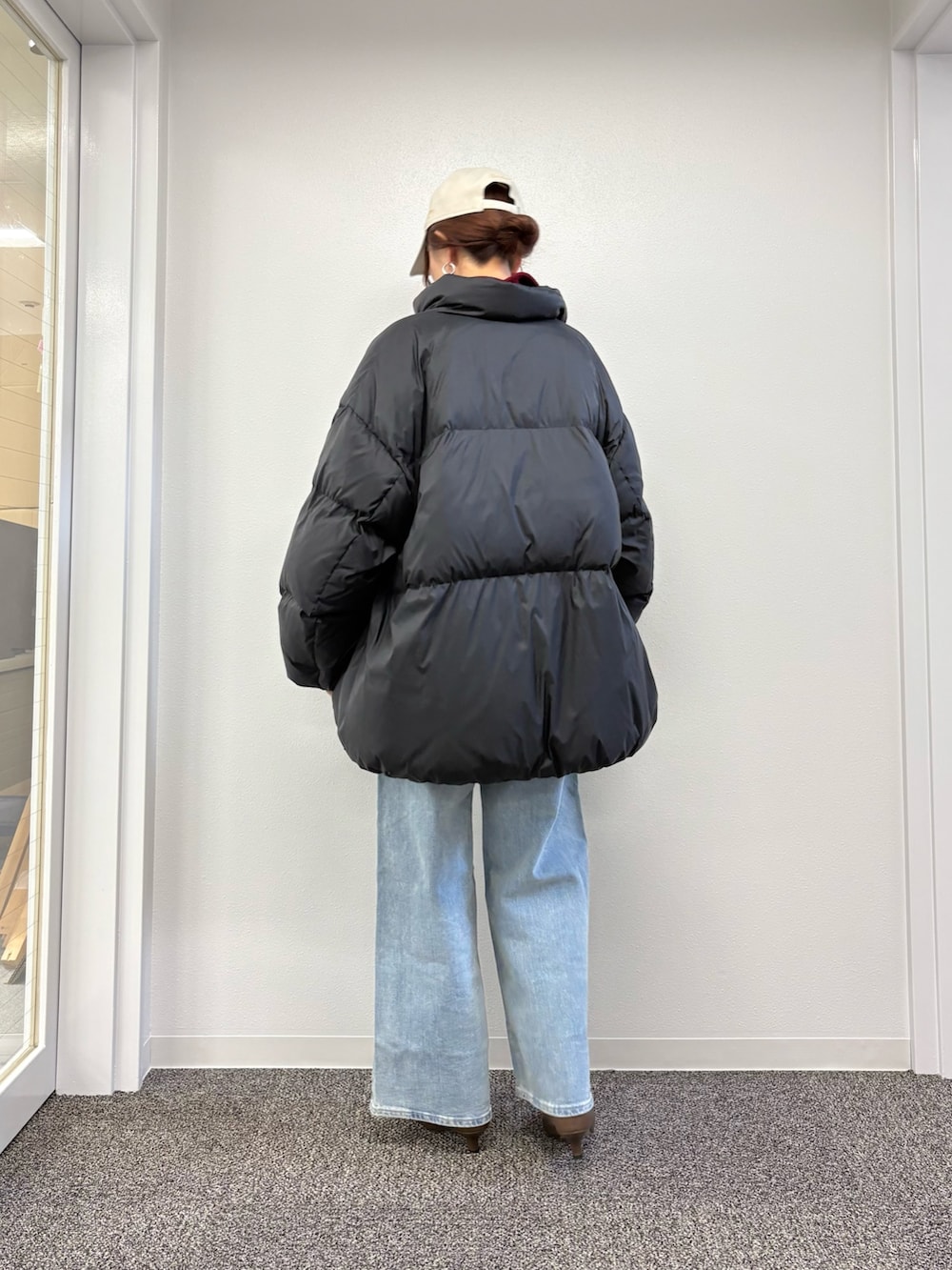 ブラック系のダウンジャケット/コート、ブルー系のデニムパンツ、ブラック系のダウンジャケット/コートを着用したレディースの秋コーディネートの3枚目の写真