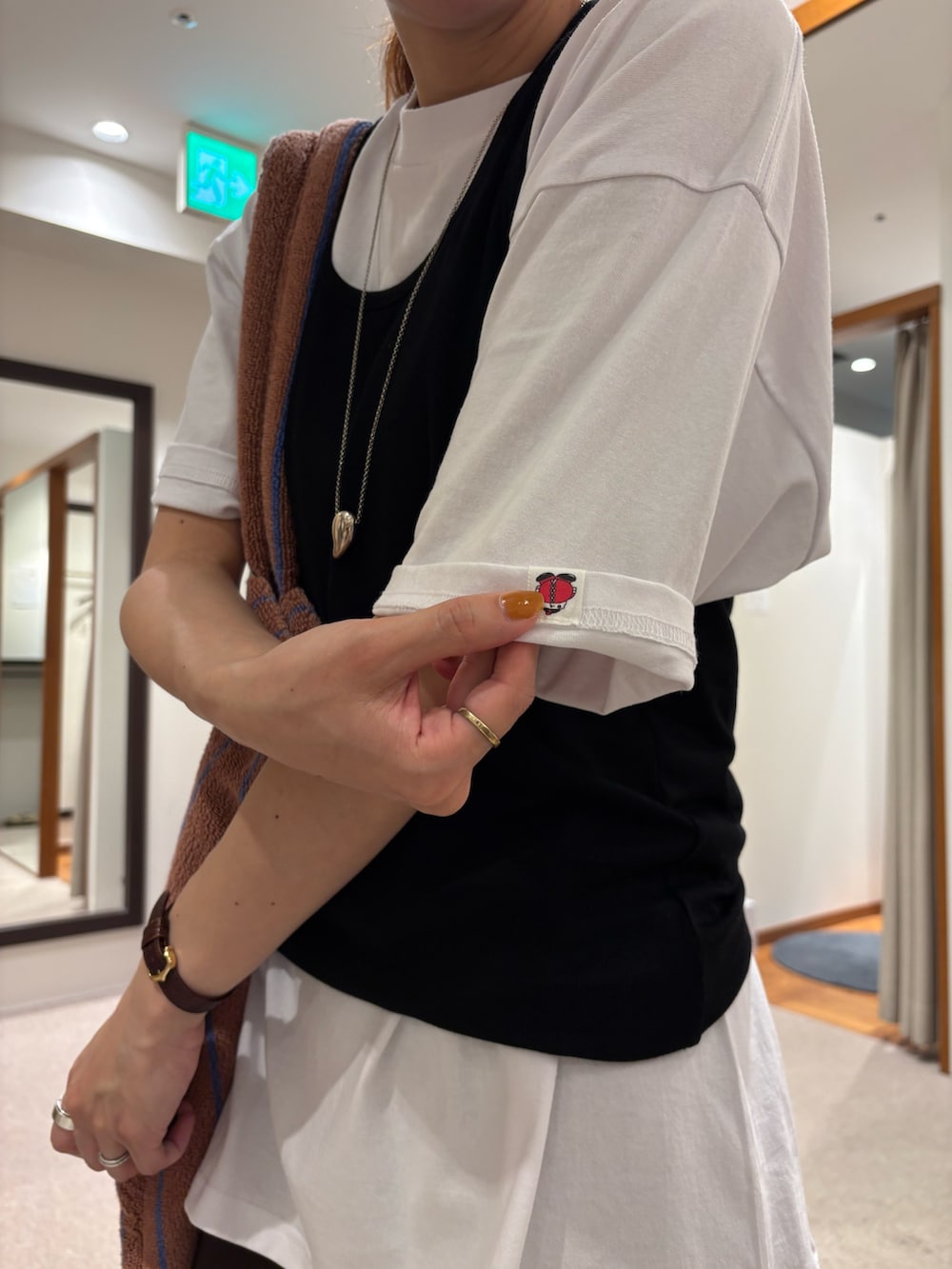 ホワイト系のTシャツ/カットソー、イエロー系のトートバッグ、ベージュ系のバレエシューズを着用したレディースの夏コーディネートの6枚目の写真
