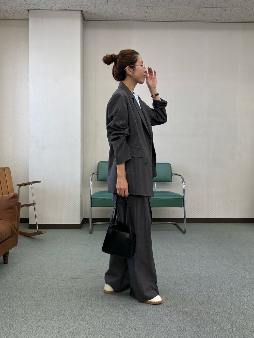 グレー系のその他パンツ、ホワイト系のスニーカー、ブラック系のハンドバッグを着用したレディースの秋コーディネートの2枚目の写真