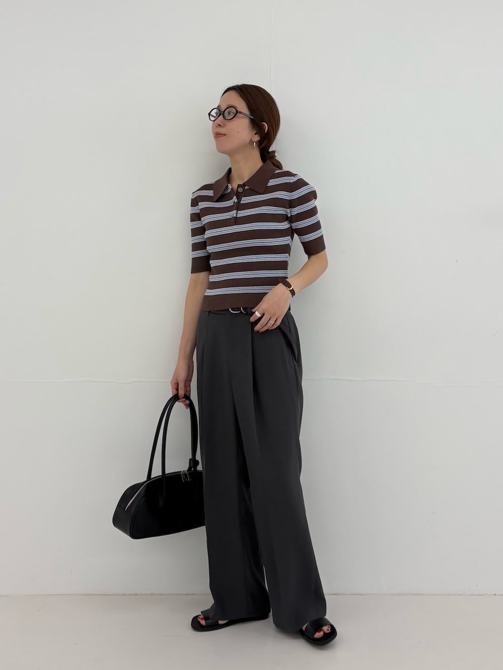 グレー系のその他パンツ、ブラウン系のニット/セーター、ブラック系のショルダーバッグを着用したレディースの春コーディネートの2枚目の写真