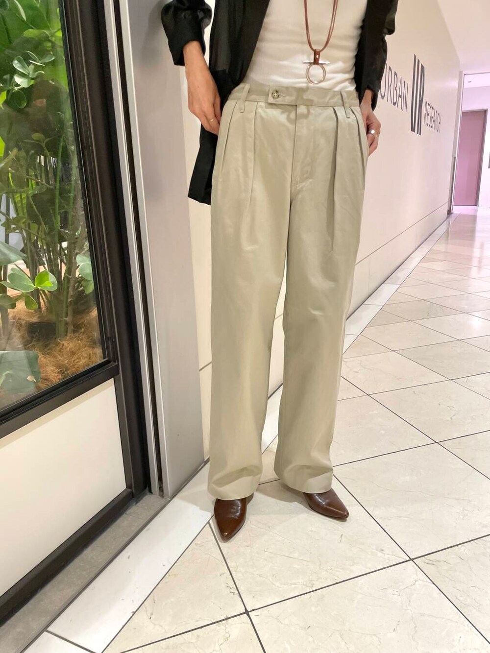 ホワイト系のタンクトップ、ブラック系のテーラードジャケット、ベージュ系のチノパンツを着用したレディースの夏コーディネートの7枚目の写真