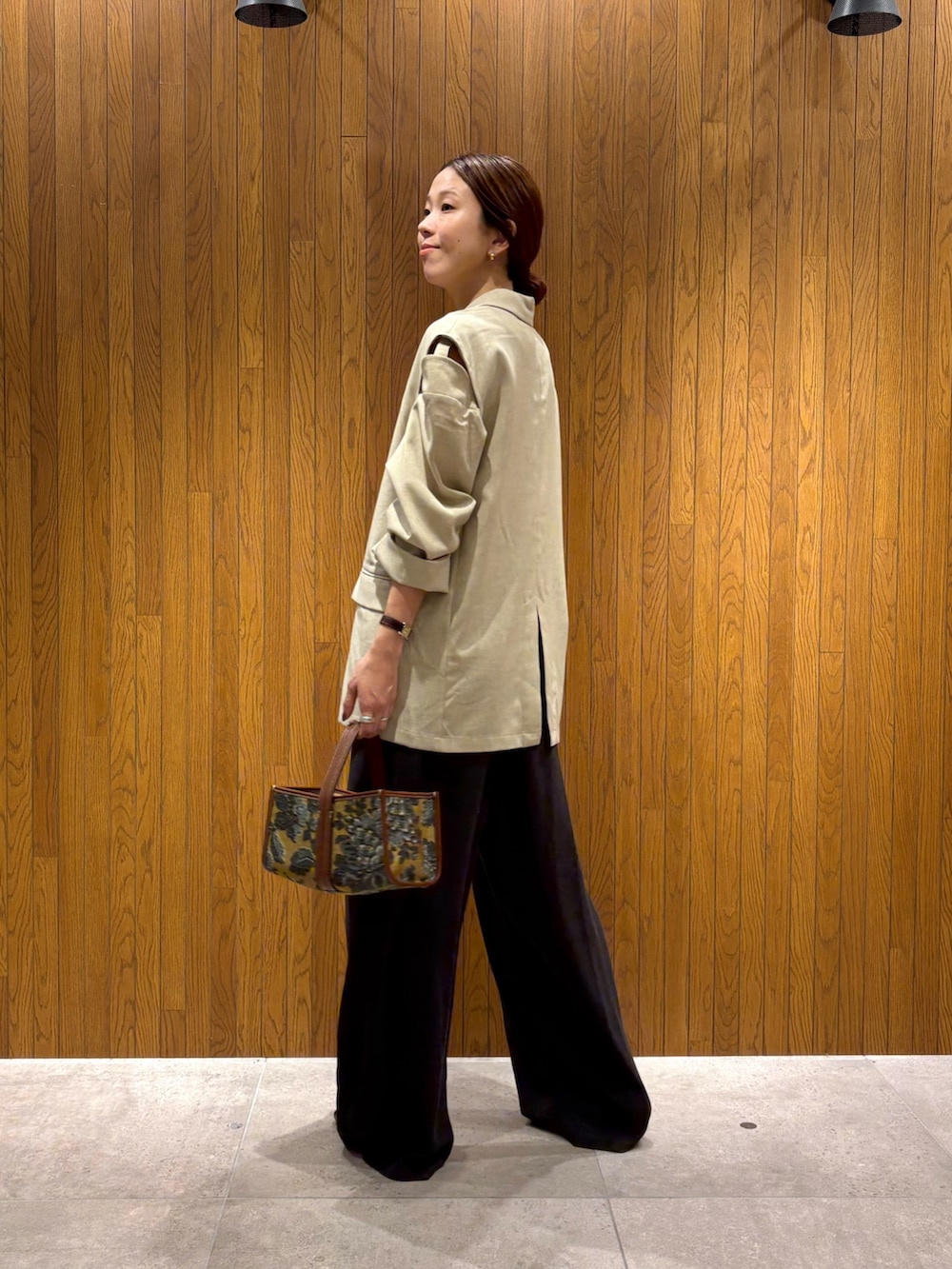 ホワイト系のその他アウター、ブラウン系のその他パンツ、ベージュ系のハンドバッグを着用したレディースの秋コーディネートの6枚目の写真