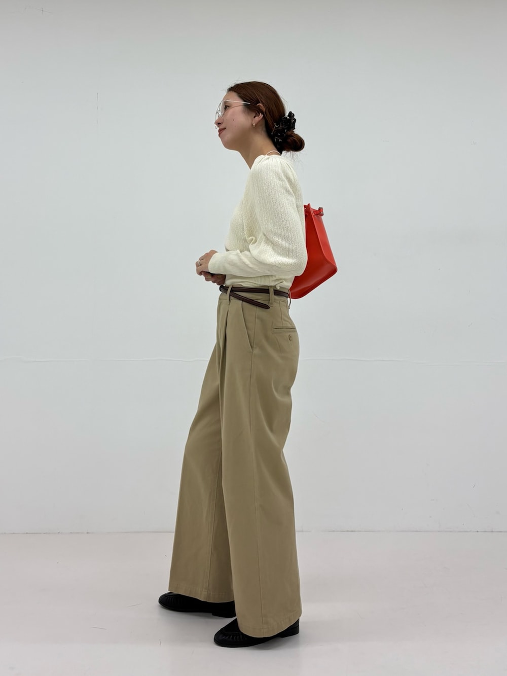 ホワイト系のニット/セーター、ベージュ系のその他パンツ、ブラック系のローファーを着用したレディースの夏コーディネートの2枚目の写真