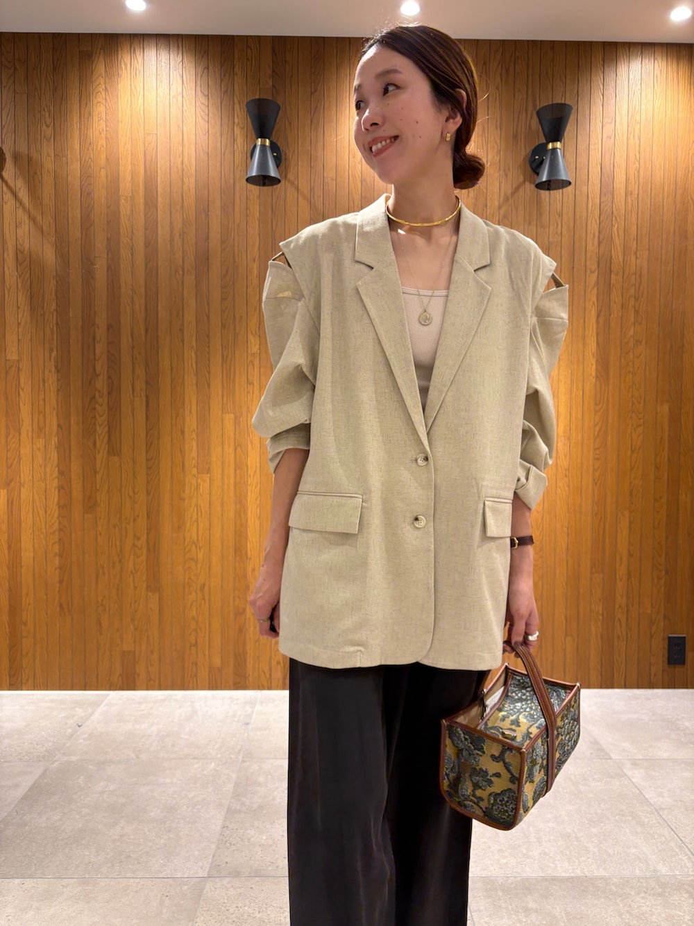 ホワイト系のその他アウター、ブラウン系のその他パンツ、ベージュ系のハンドバッグを着用したレディースの秋コーディネートの9枚目の写真