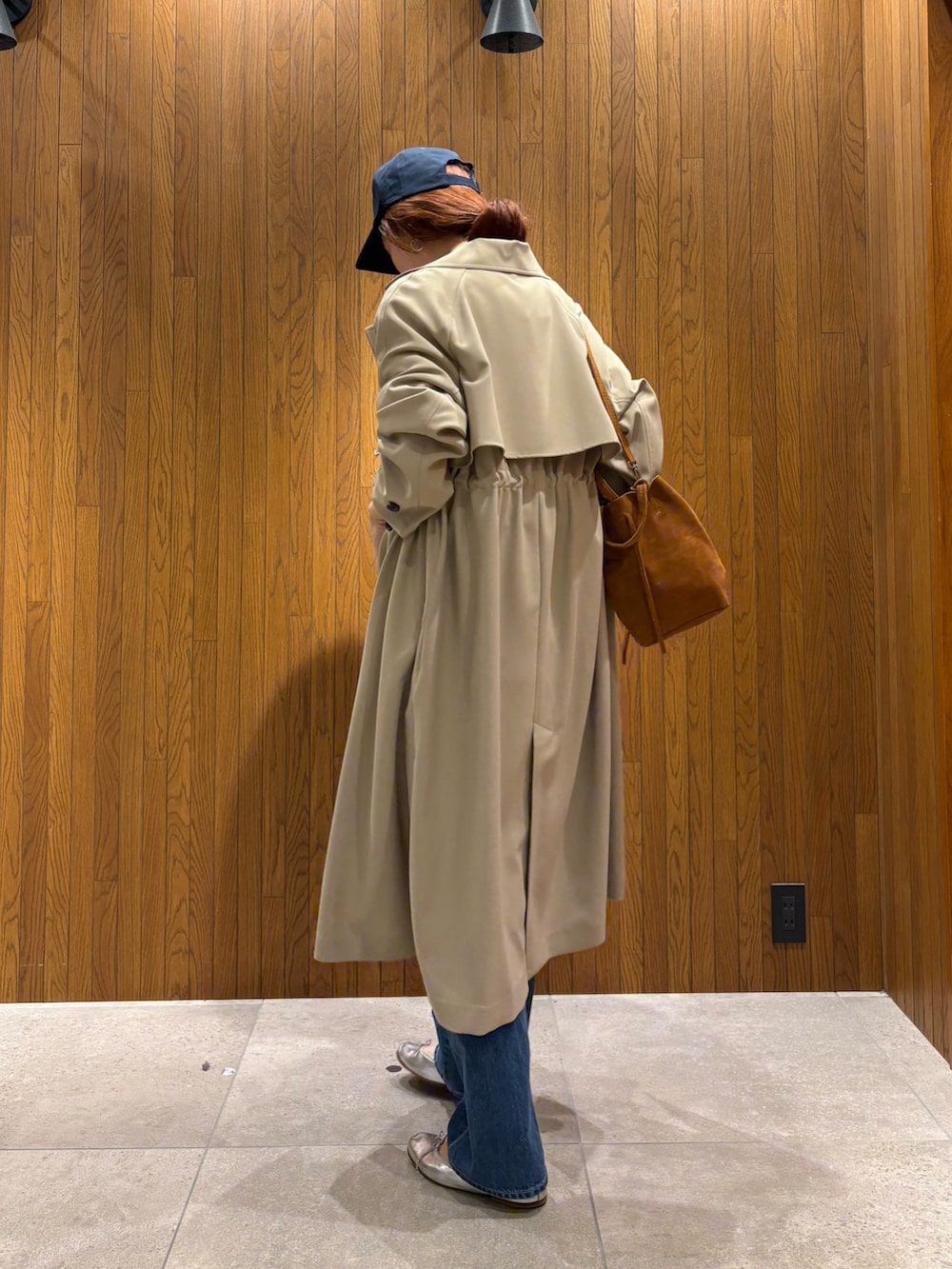 ベージュ系のトレンチコート、レッド系のTシャツ/カットソー、ホワイト系のニット/セーターを着用したレディースの春コーディネートの4枚目の写真