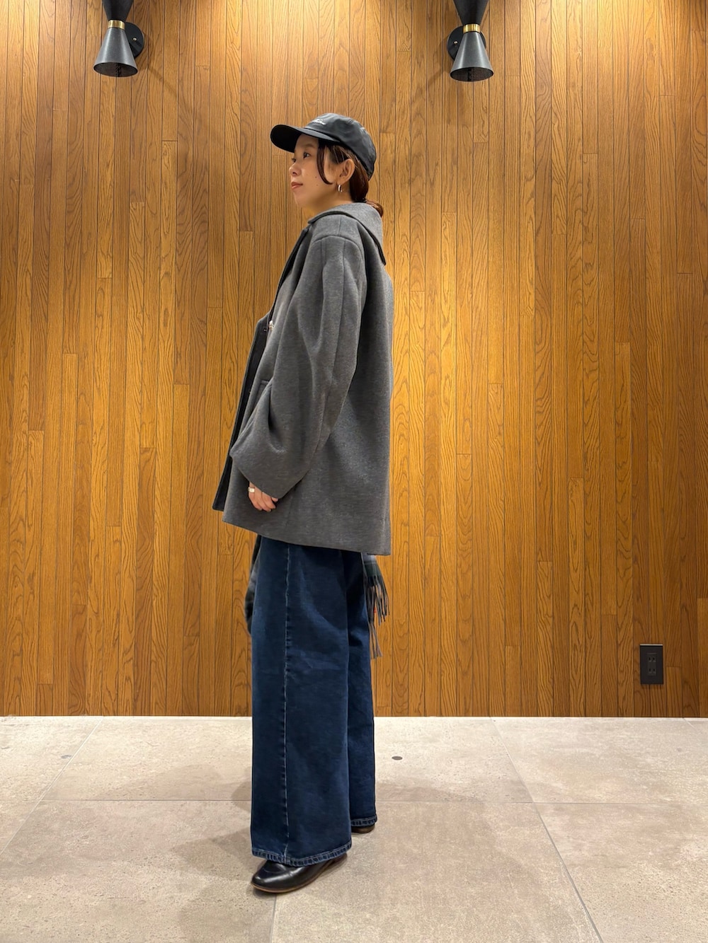 グレー系のその他アウター、イエロー系のニット/セーター、ブルー系のデニムパンツを着用したレディースの冬コーディネートの2枚目の写真