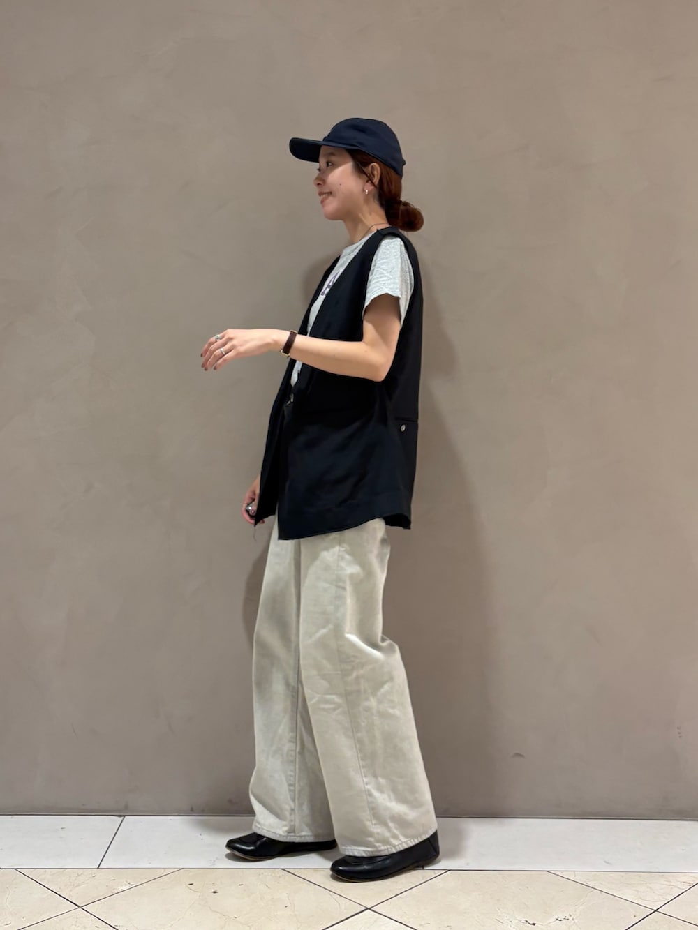 グレー系のデニムパンツ、ブラック系のダウンベストを着用したレディースの夏コーディネートの5枚目の写真