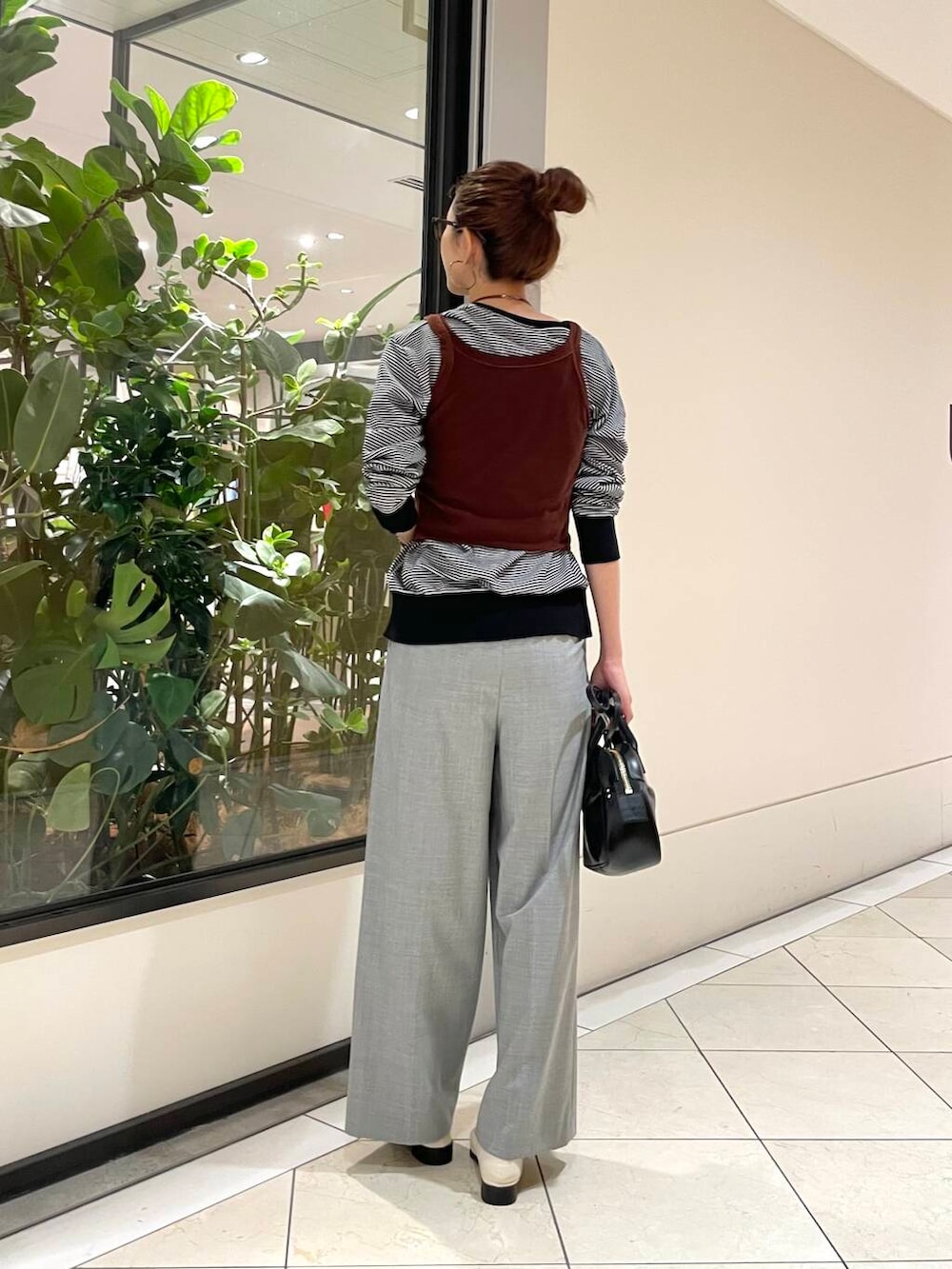 ブラック系のショルダーバッグ、ホワイト系のニット/セーター、グレー系のその他パンツを着用したレディースの秋コーディネートの4枚目の写真