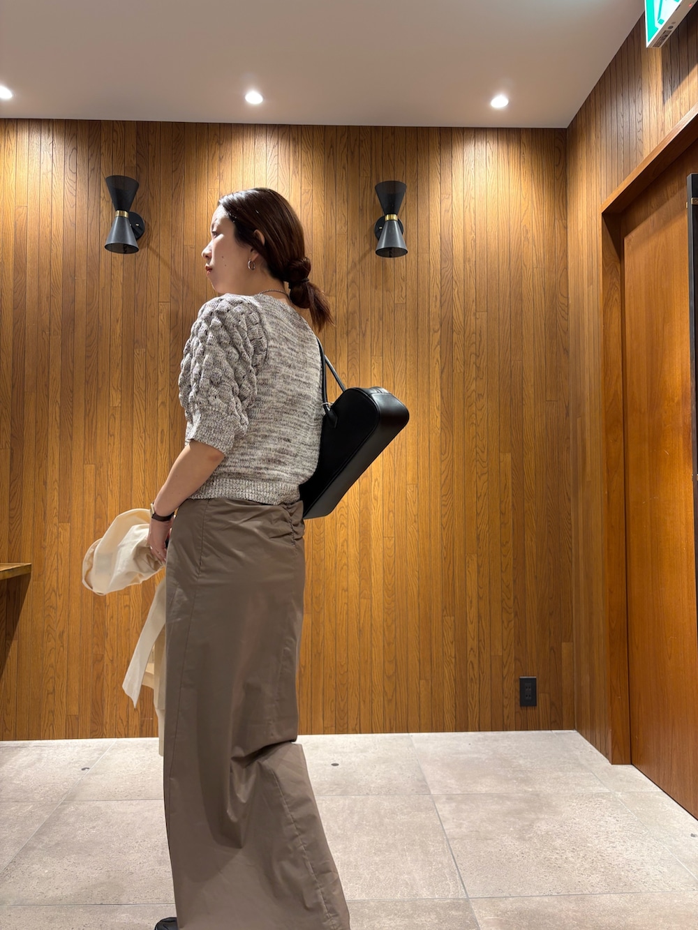 グレー系のスカート、その他のニット/セーター、ブラック系のスニーカーを着用したレディースの春コーディネートの9枚目の写真