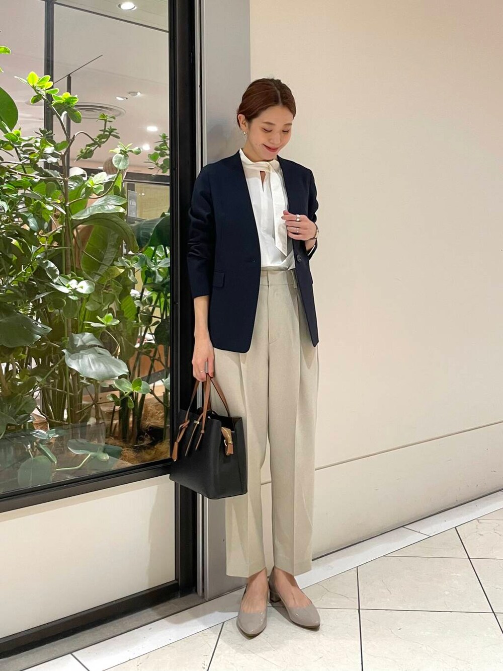 ブラック系のトートバッグ、ベージュ系のパンプス、ホワイト系のシャツ/ブラウスを着用したレディースの冬コーディネートの2枚目の写真