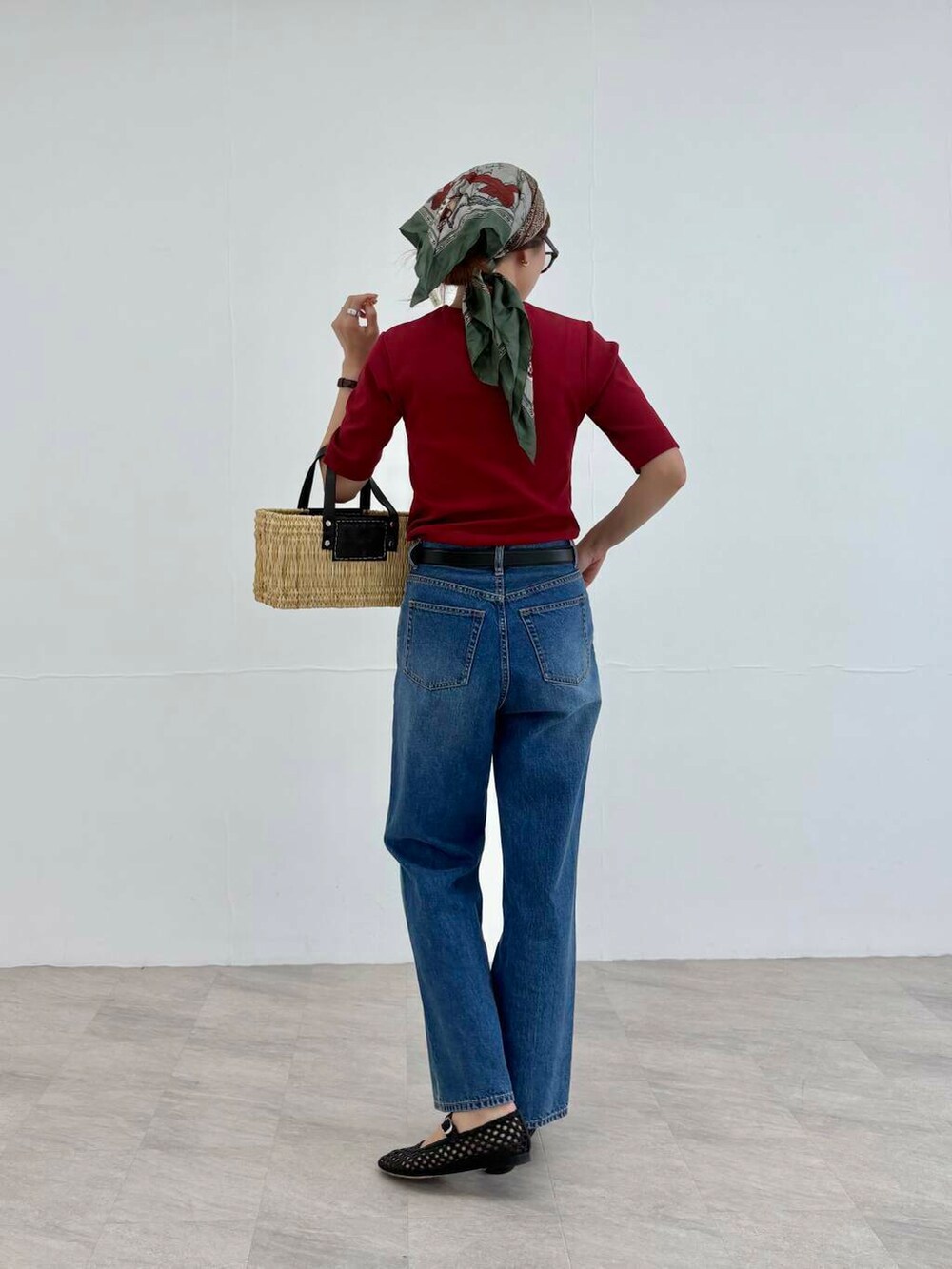 ブラック系のかごバッグ、ブルー系のデニムパンツ、レッド系のTシャツ/カットソーを着用したレディースの夏コーディネートの4枚目の写真