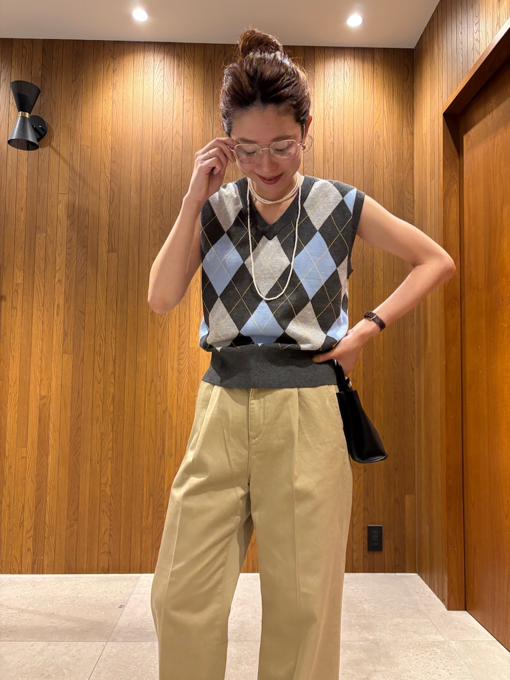 グレー系のベスト、ベージュ系のその他パンツ、ブラック系のハンドバッグを着用したレディースの夏コーディネートの6枚目の写真