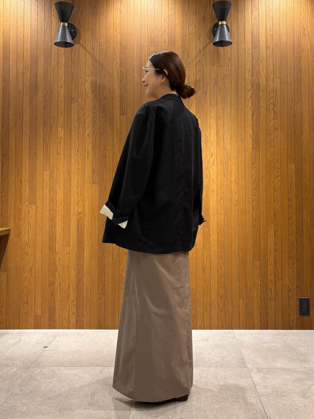 ブラック系のその他アウター、ブラック系のパンプス、ブラウン系のニット/セーターを着用したレディースの春コーディネートの2枚目の写真