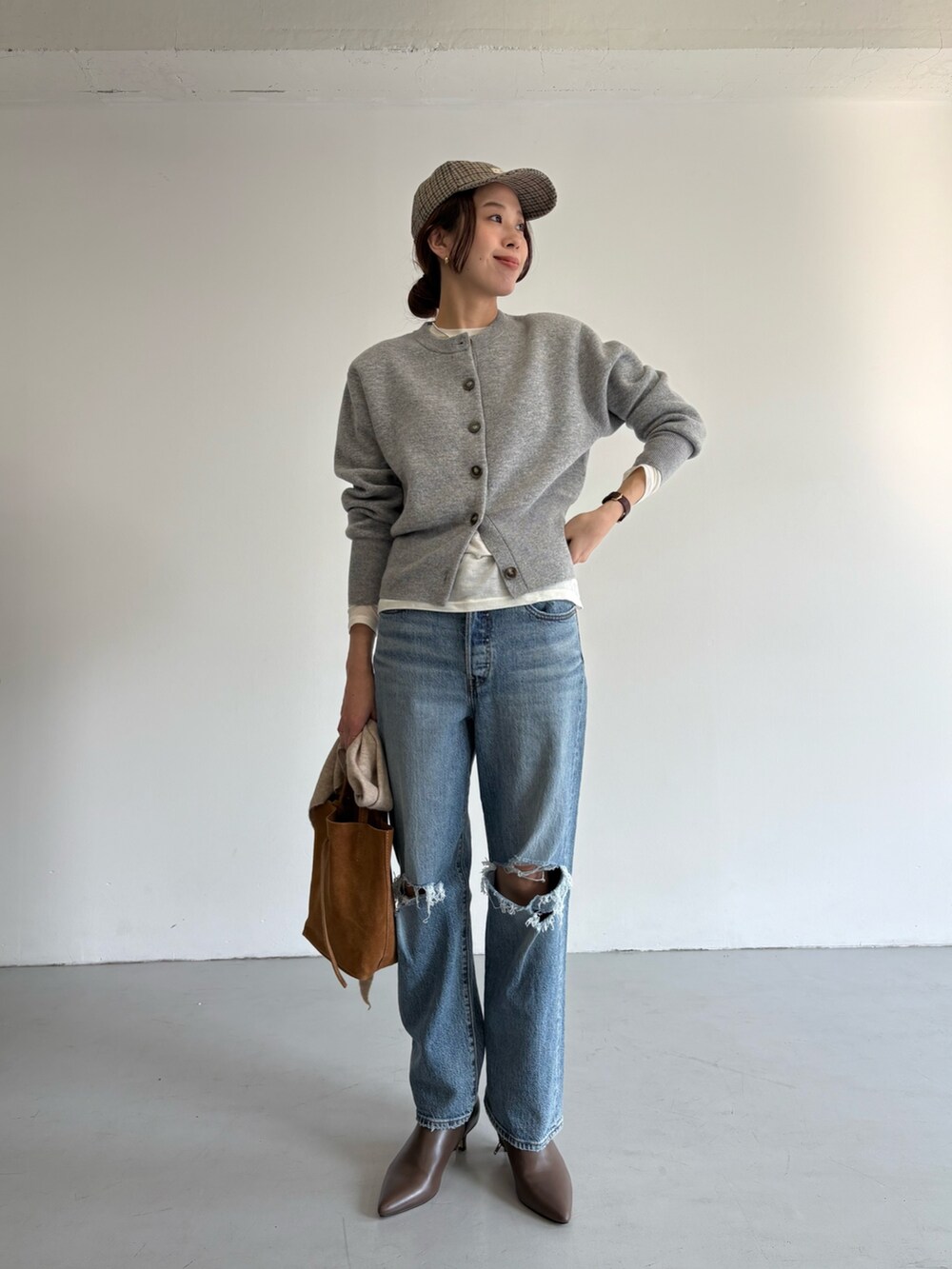ブルー系のデニムパンツ、ベージュ系のトートバッグ、ホワイト系のTシャツ/カットソーを着用したレディースの冬コーディネートの7枚目の写真