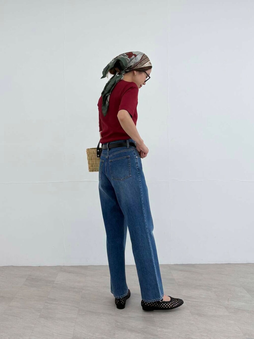 ブラック系のかごバッグ、ブルー系のデニムパンツ、レッド系のTシャツ/カットソーを着用したレディースの夏コーディネートの6枚目の写真