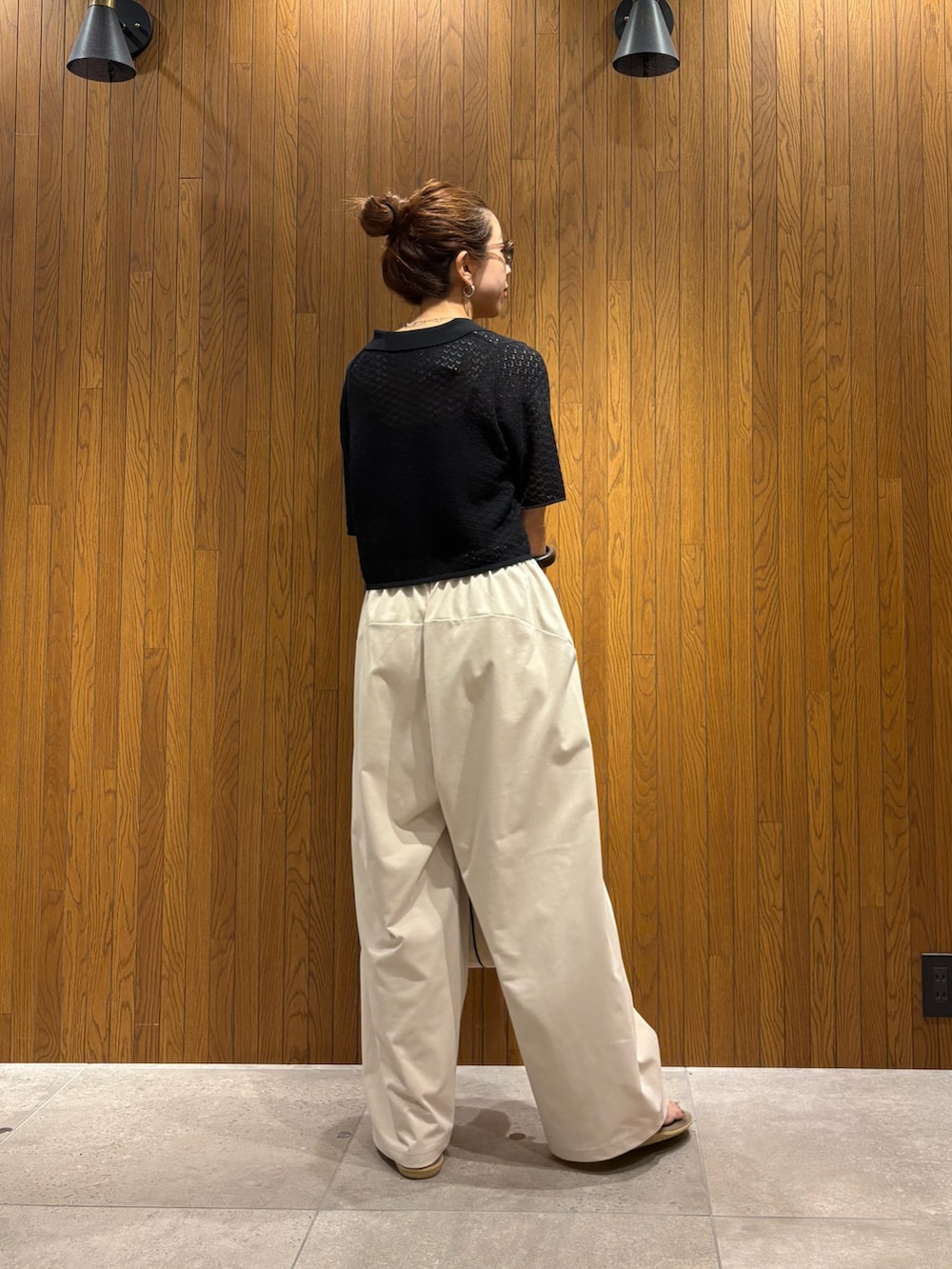 ブラック系のニット/セーター、ホワイト系のその他パンツ、ホワイト系のハンドバッグを着用したレディースの春コーディネートの3枚目の写真