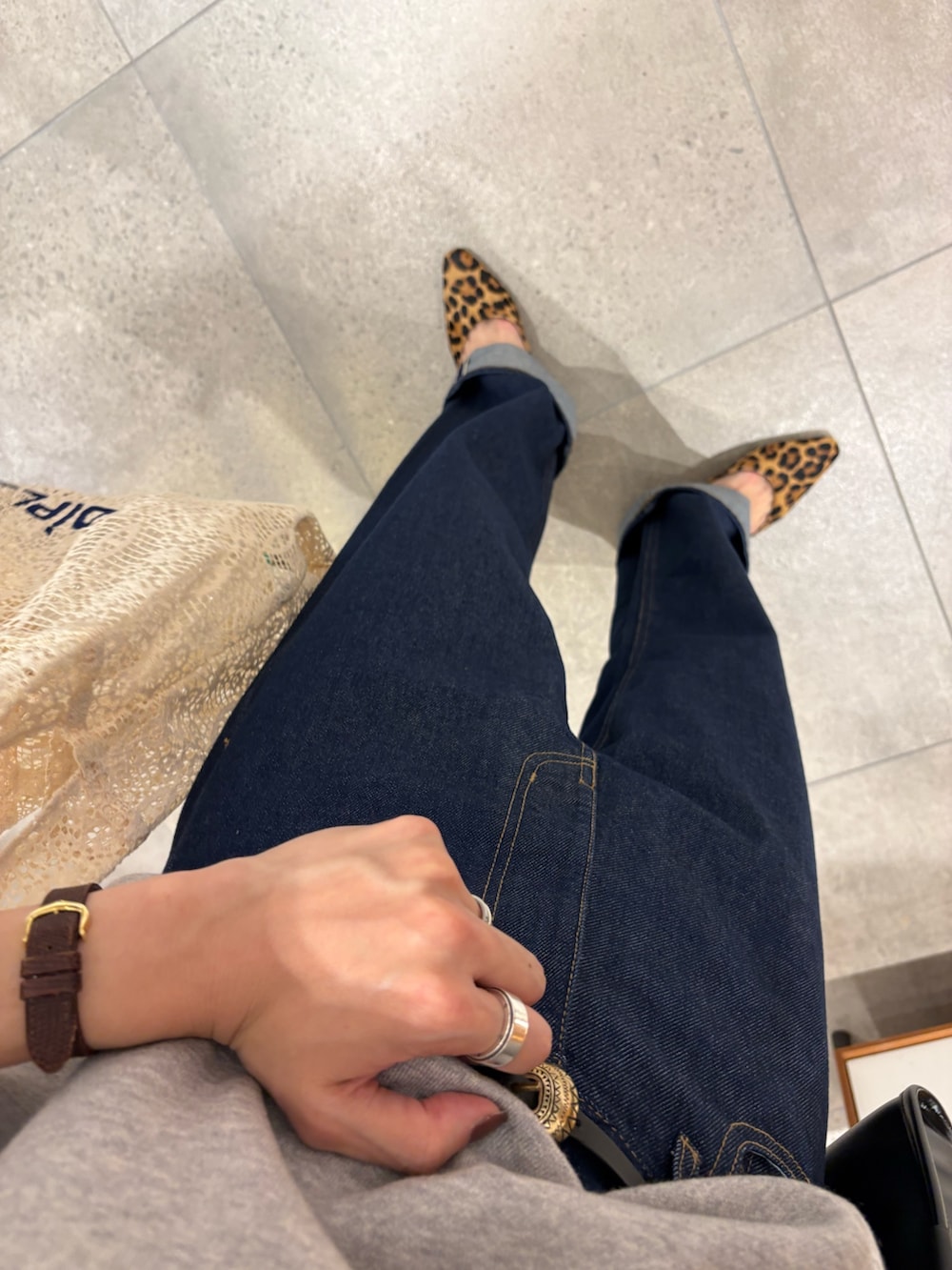 ホワイト系のハンドバッグ、ブルー系のデニムパンツ、ブラック系のショルダーバッグを着用したレディースの秋コーディネートの7枚目の写真