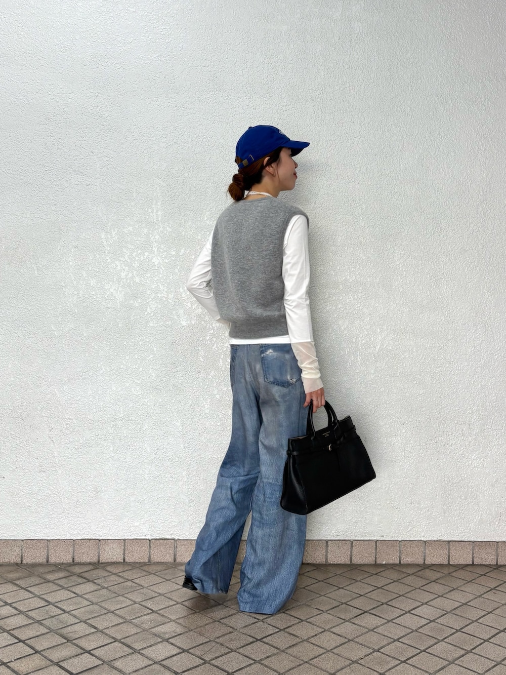 ブルー系のその他パンツ、グレー系のニット/セーター、ホワイト系のTシャツ/カットソーを着用したレディースの秋コーディネートの5枚目の写真