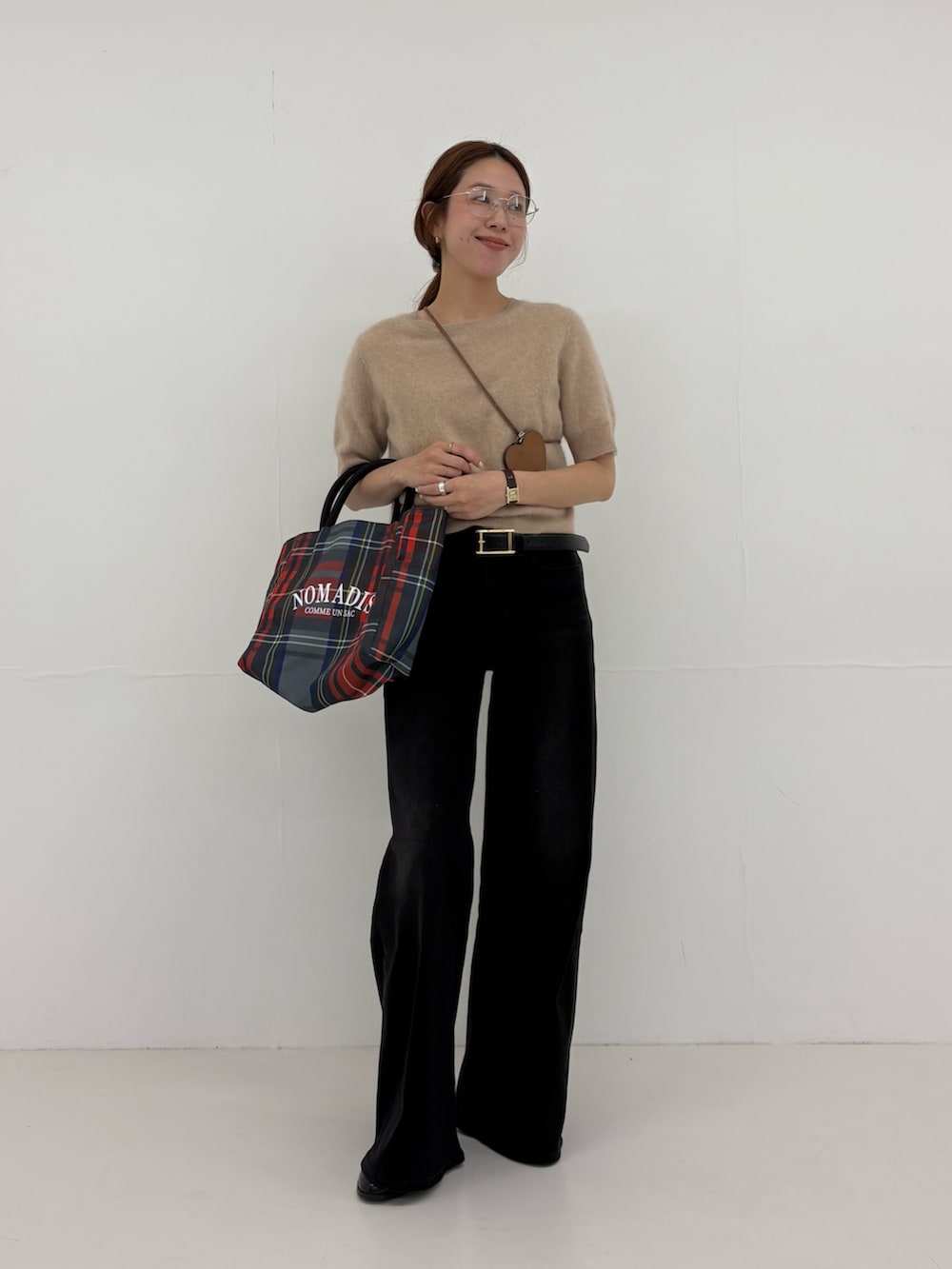 ブラック系のデニムパンツ、グレー系のトートバッグ、ベージュ系のニット/セーターを着用したレディースの夏コーディネートの4枚目の写真