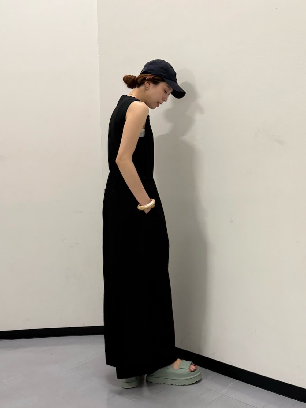 ブラック系のその他パンツ、ホワイト系のハンドバッグ、ブルー系のキャップを着用したレディースの春コーディネートの2枚目の写真