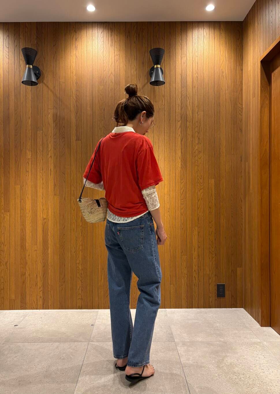 ブルー系のデニムパンツ、ブラック系のサンダル、レッド系のTシャツ/カットソーを着用したレディースの夏コーディネートの4枚目の写真