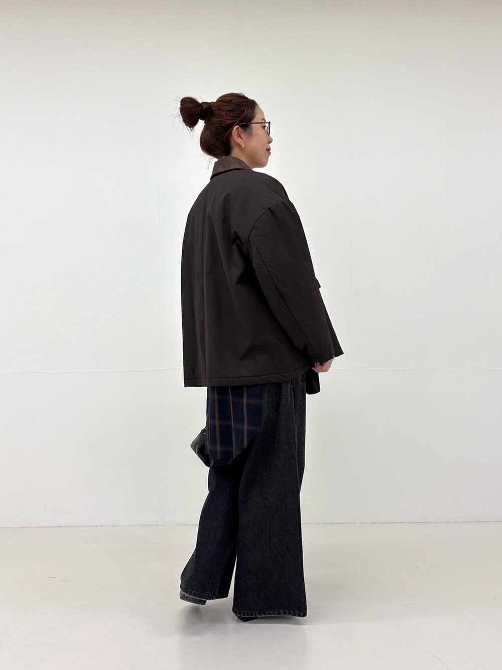 ホワイト系のシャツ/ブラウス、ブラック系のデニムパンツ、ブラック系のハンドバッグを着用したレディースの秋コーディネートの2枚目の写真