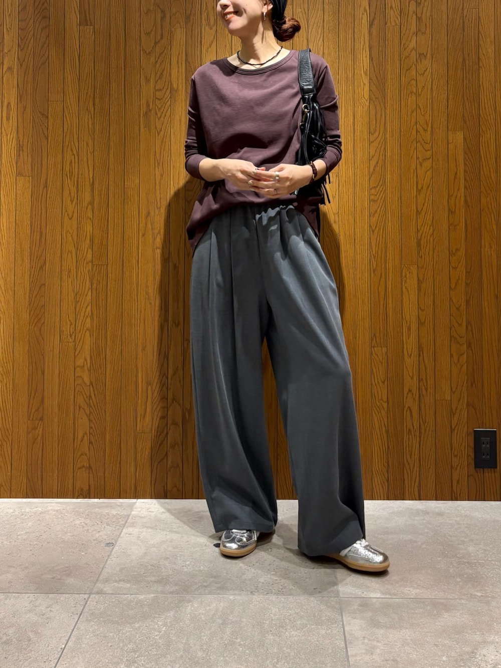 グレー系のその他パンツ、シルバー系のスニーカー、ブラック系のハンドバッグを着用したレディースの春コーディネートの2枚目の写真