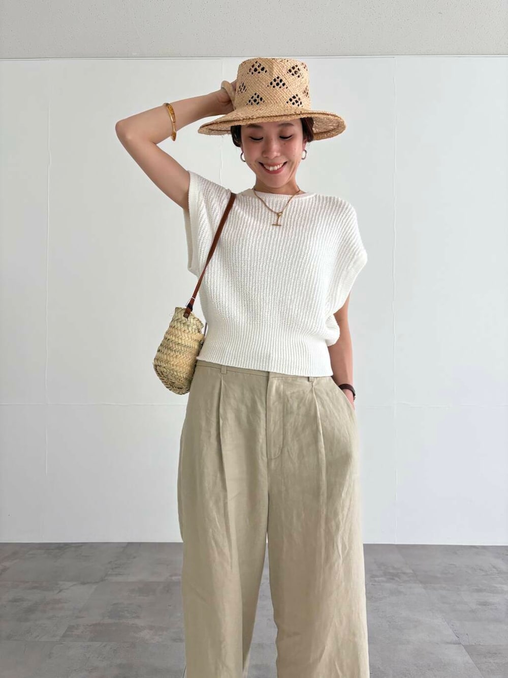 ベージュ系のその他パンツ、ホワイト系のベスト、ブラック系のサンダルを着用したレディースの夏コーディネートの6枚目の写真