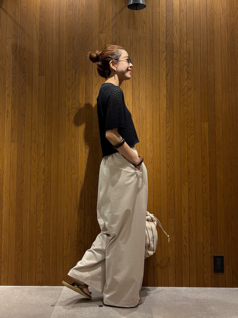 ブラック系のニット/セーター、ホワイト系のその他パンツ、ホワイト系のハンドバッグを着用したレディースの春コーディネートの2枚目の写真