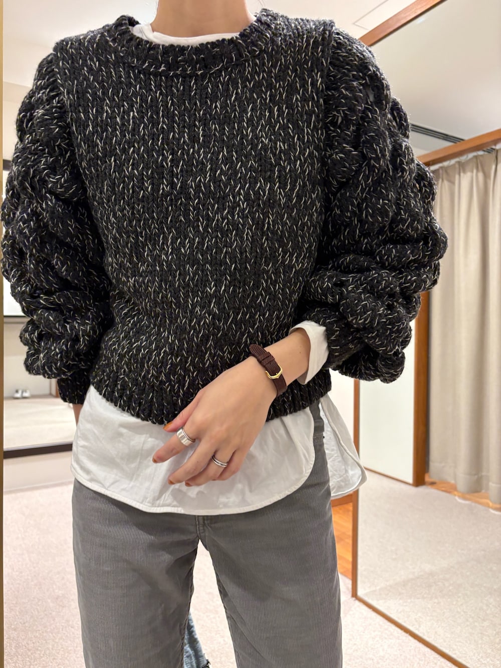 ブラック系のニット/セーター、グリーン系のショルダーバッグ、ブラック系のバレエシューズを着用したレディースの冬コーディネートの6枚目の写真