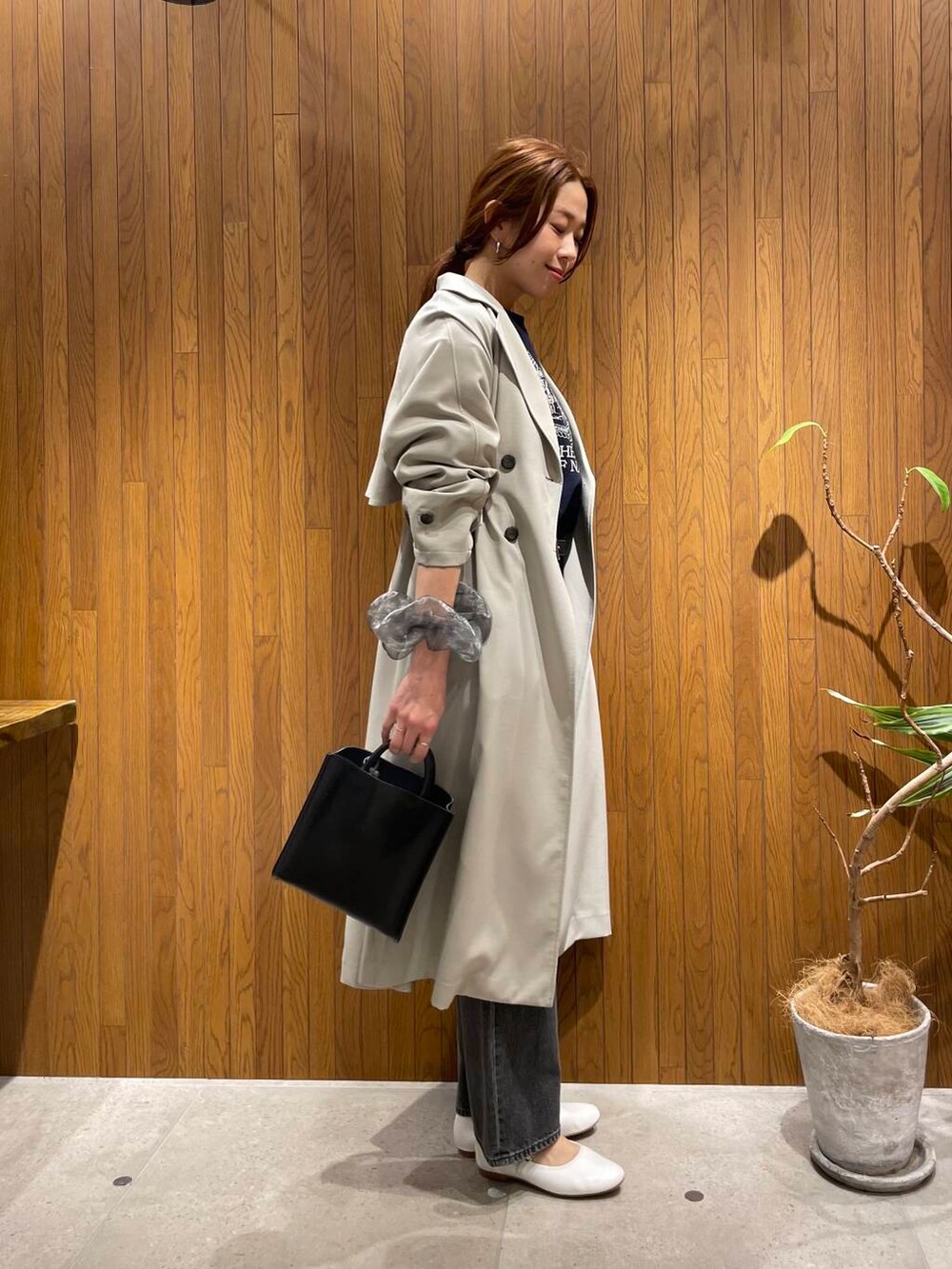 ブラック系のデニムパンツ、ブラック系のトートバッグ、ブルー系のスウェットを着用したレディースの冬コーディネートの2枚目の写真