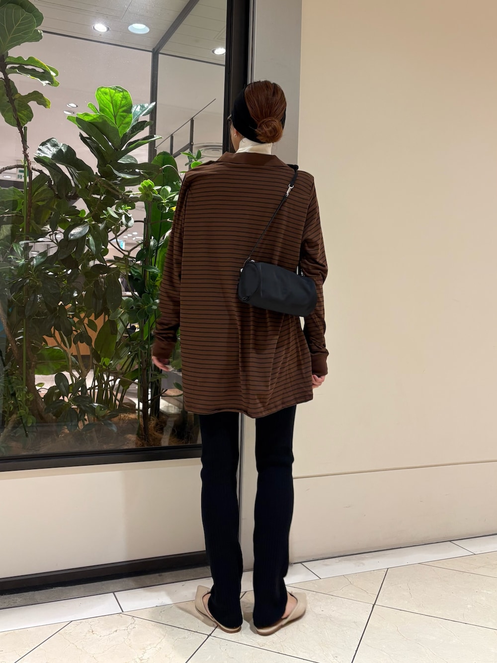ブラウン系のポロシャツ、ブラック系のその他パンツ、ブラック系のハンドバッグを着用したレディースの秋コーディネートの3枚目の写真