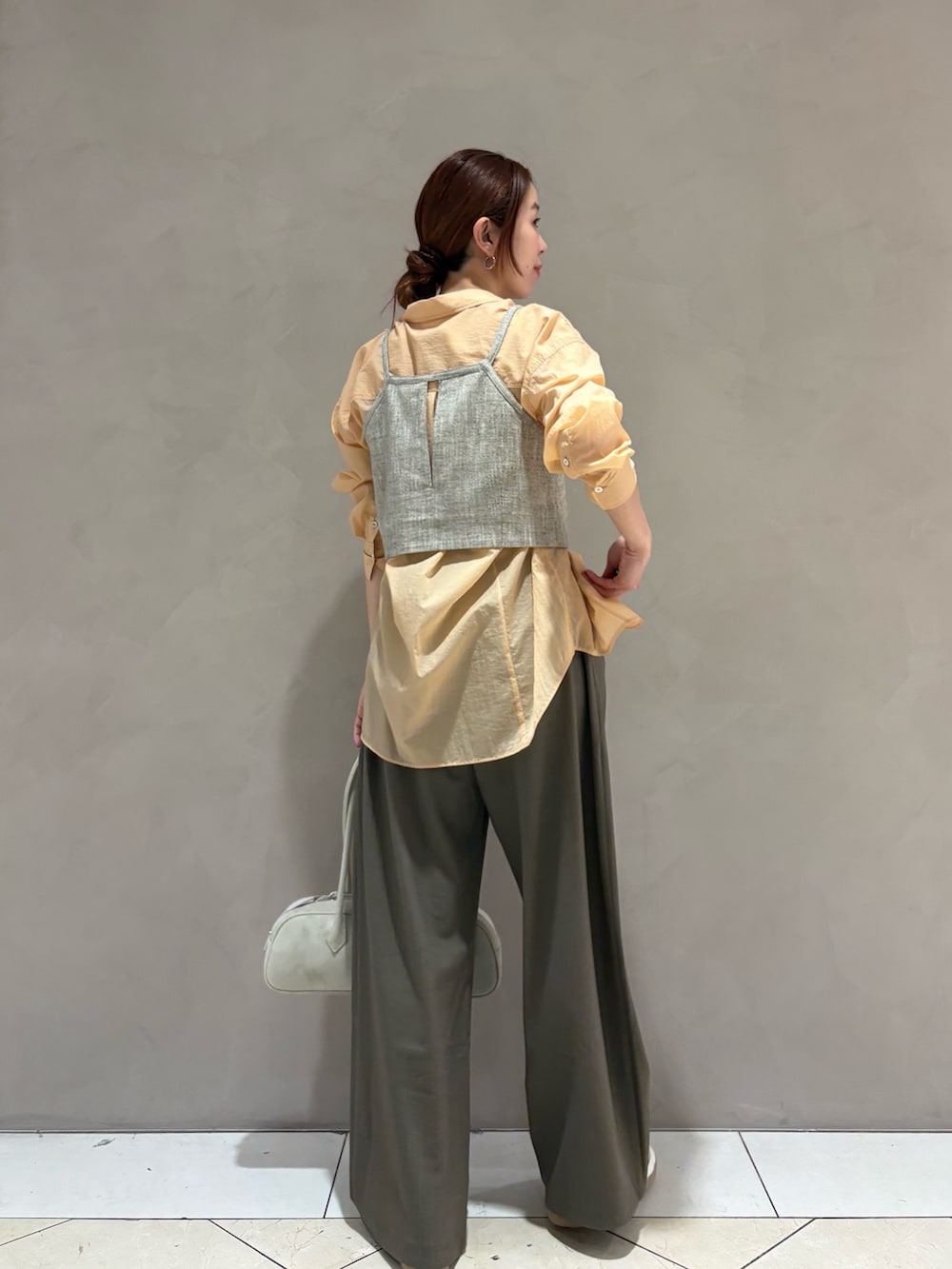 オレンジ系のシャツ/ブラウス、ベージュ系のその他トップス、ホワイト系のスニーカーを着用したレディースの春コーディネートの3枚目の写真