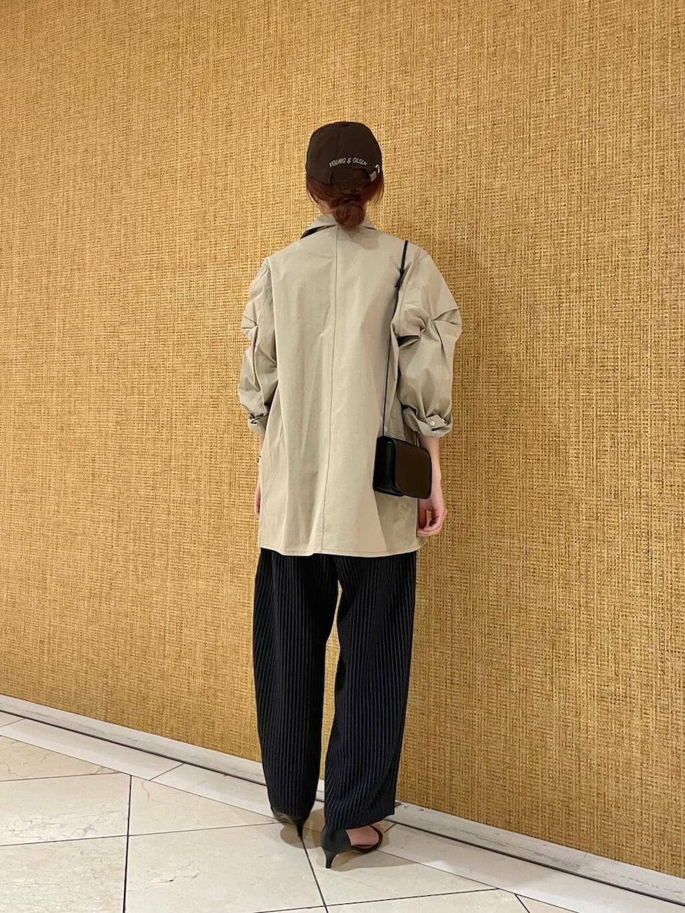 ブラック系のショルダーバッグ、ブルー系のその他パンツ、ブラウン系のその他アウターを着用したレディースの冬コーディネートの3枚目の写真