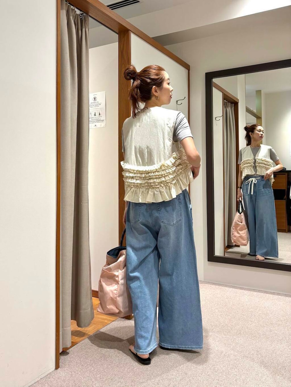 ピンク系のトートバッグ、ブルー系のデニムパンツ、ホワイト系のシャツ/ブラウスを着用したレディースの夏コーディネートの3枚目の写真