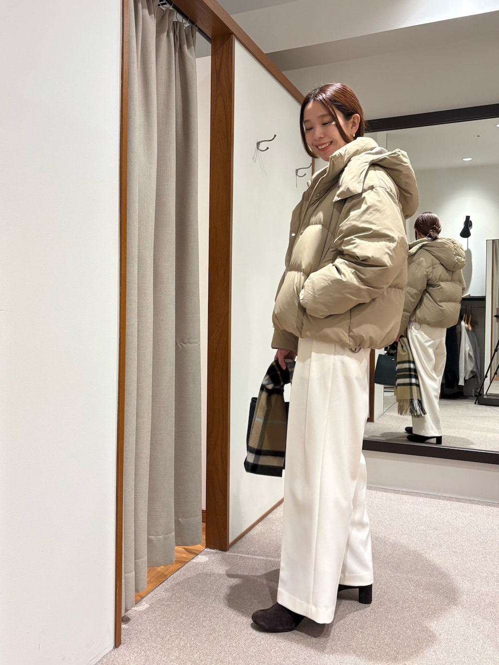 ベージュ系のダウンジャケット/コート、グリーン系のニット/セーター、ホワイト系のその他パンツを着用したレディースの秋コーディネートの5枚目の写真