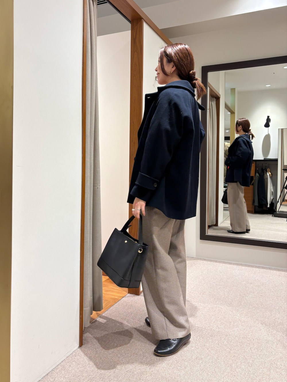 グレー系のピーコート、レッド系のスウェット、イエロー系のその他パンツを着用したレディースの秋コーディネートの4枚目の写真