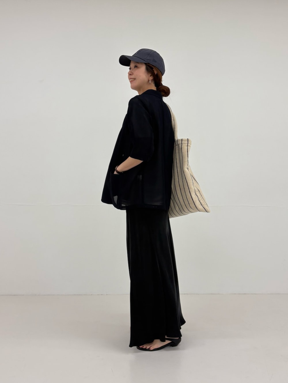 ブルー系のその他アウター、ブラック系のスカート、ベージュ系のTシャツ/カットソーを着用したレディースの春コーディネートの4枚目の写真