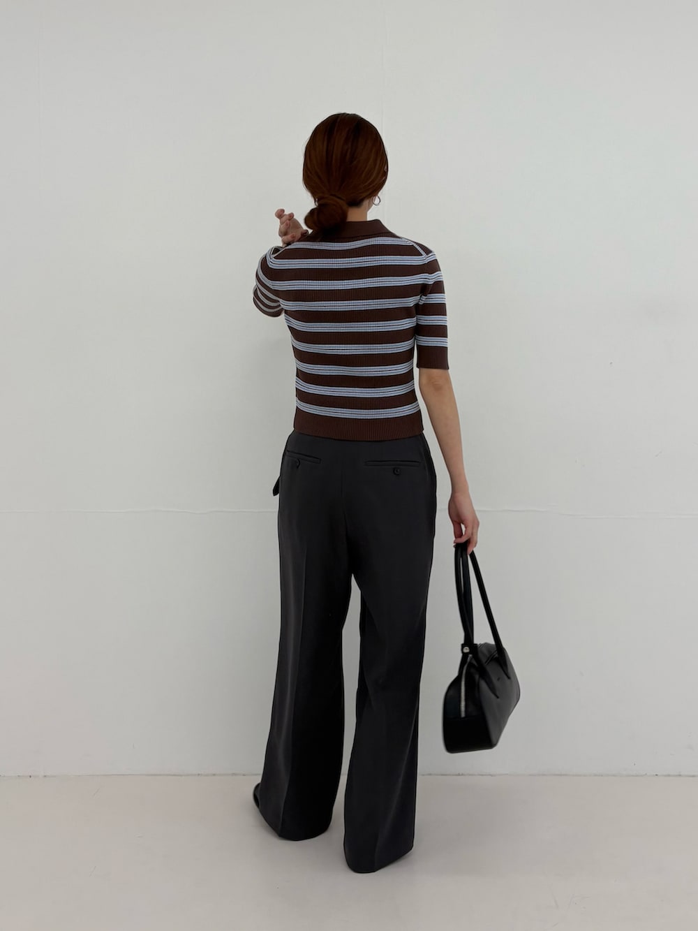 グレー系のその他パンツ、ブラウン系のニット/セーター、ブラック系のショルダーバッグを着用したレディースの春コーディネートの4枚目の写真