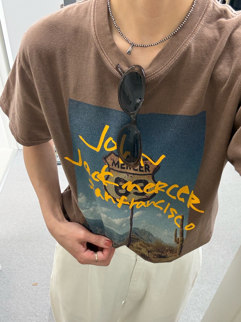 ブラウン系のTシャツ/カットソー、ホワイト系のデニムパンツ、ブラック系のサンダルを着用したレディースの夏コーディネートの4枚目の写真