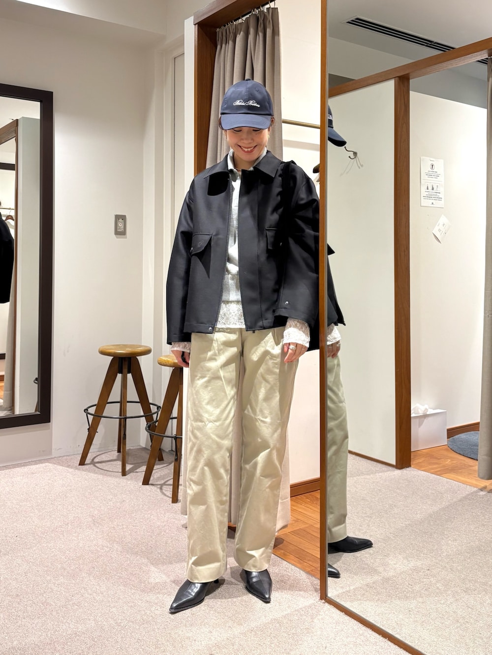 ベージュ系のチノパンツ、ブラック系のその他アウター、グレー系のスウェットを着用したレディースの冬コーディネートの4枚目の写真