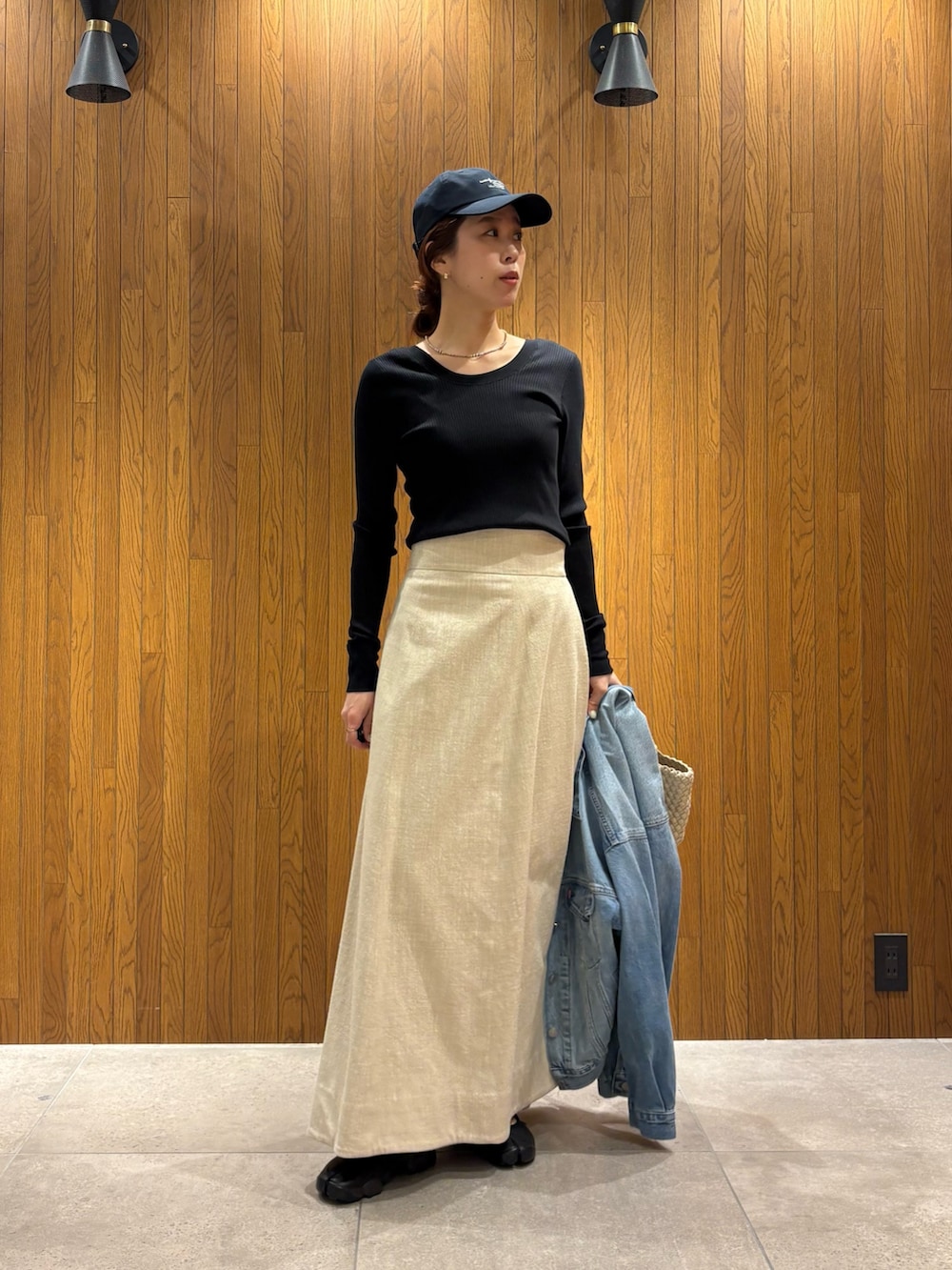 ホワイト系のトートバッグ、ブラック系のTシャツ/カットソー、ブルー系のデニムジャケットを着用したレディースの春コーディネートの7枚目の写真