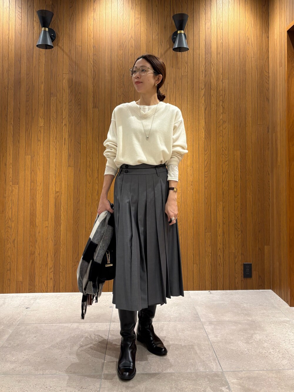 グレー系のダウンジャケット/コート、グリーン系のスカート、ブラック系のショルダーバッグを着用したレディースの冬コーディネートの6枚目の写真