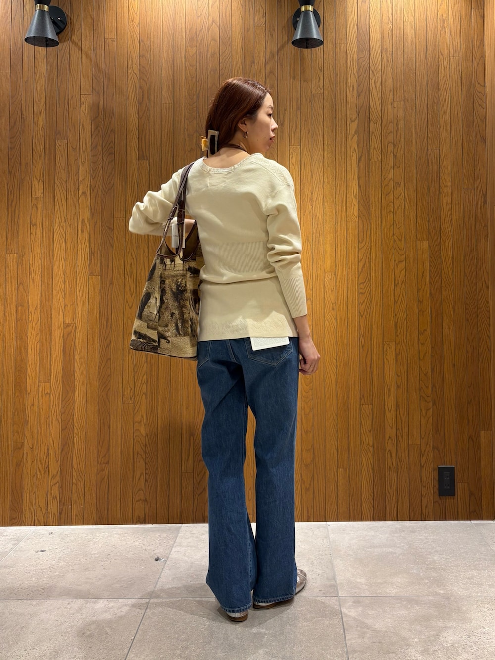 ホワイト系のニット/セーター、ブルー系のデニムパンツを着用したレディースの春コーディネートの3枚目の写真