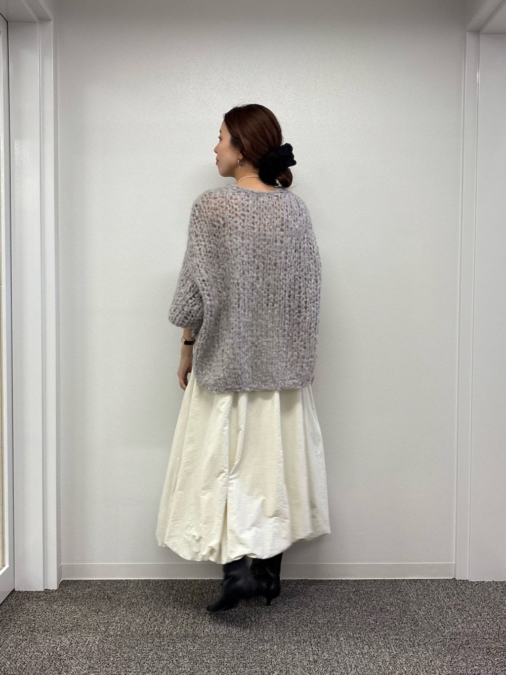 ホワイト系のスカート、ブラック系のブーツ、グレー系のニット/セーターを着用したレディースの秋コーディネートの3枚目の写真