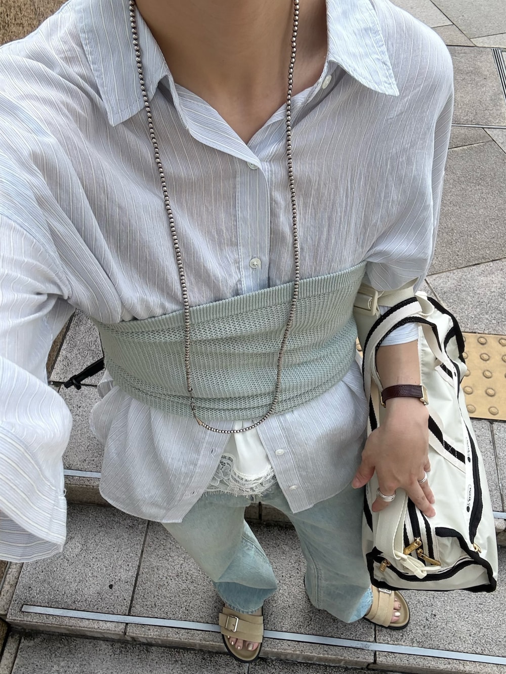 ブルー系のシャツ/ブラウス、ベージュ系のショルダーバッグ、ブルー系のデニムパンツを着用したレディースの夏コーディネートの10枚目の写真