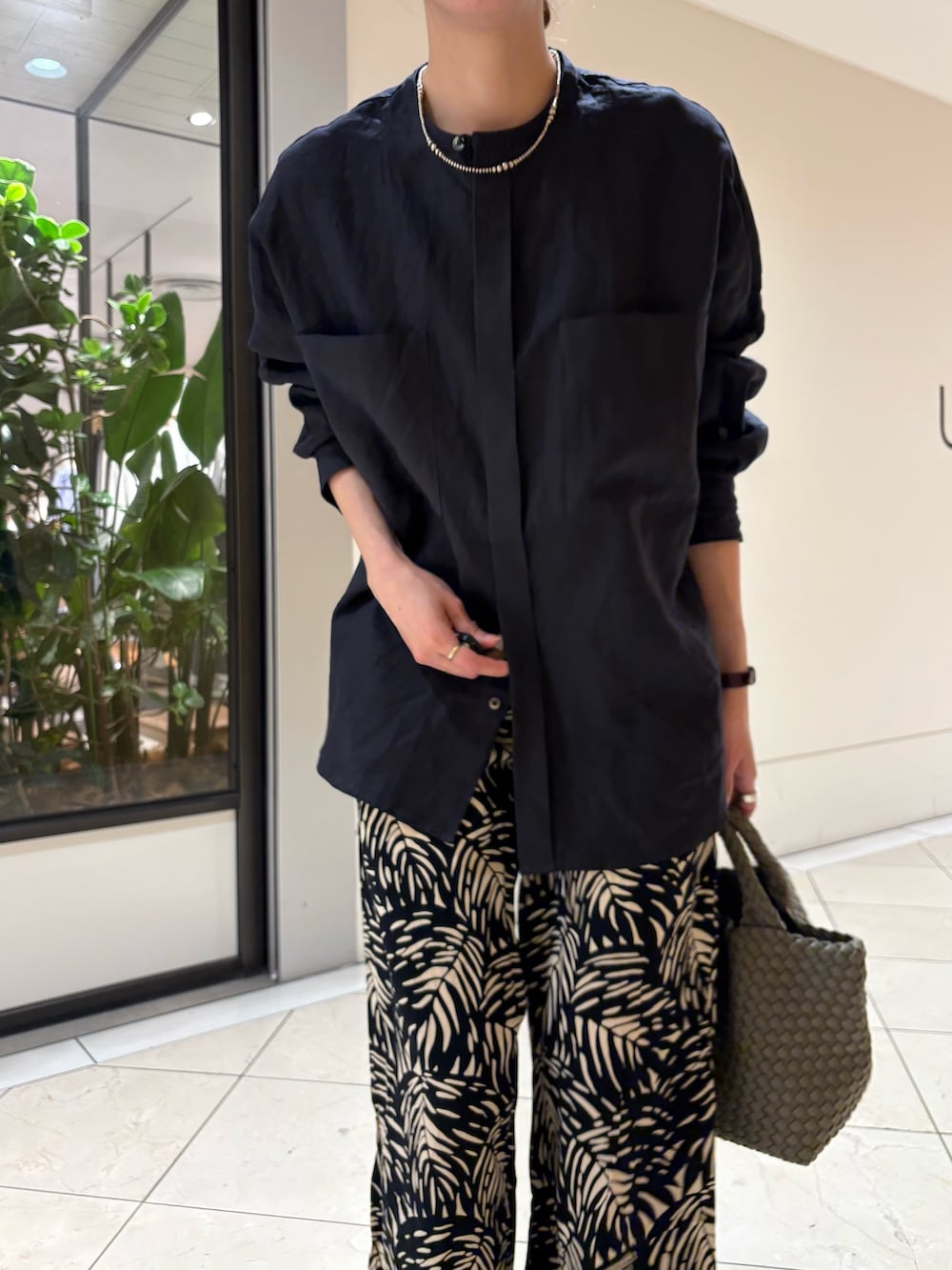 ブルー系のシャツ/ブラウス、ブラック系のその他パンツ、グリーン系のトートバッグを着用したレディースの春コーディネートの6枚目の写真