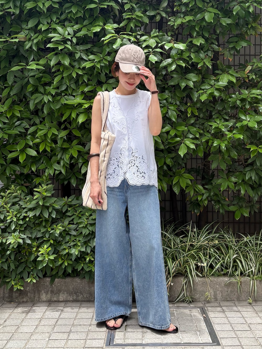 ホワイト系のシャツ/ブラウス、ブルー系のデニムパンツ、ホワイト系のトートバッグを着用したレディースの夏コーディネートの2枚目の写真