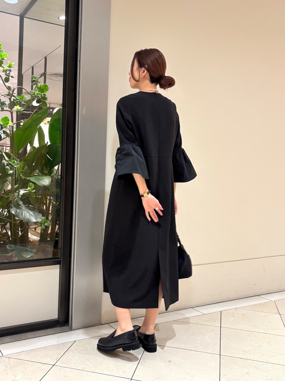 ブラック系のワンピース、ブラック系のローファー、ブラック系のショルダーバッグを着用したレディースの冬コーディネートの3枚目の写真